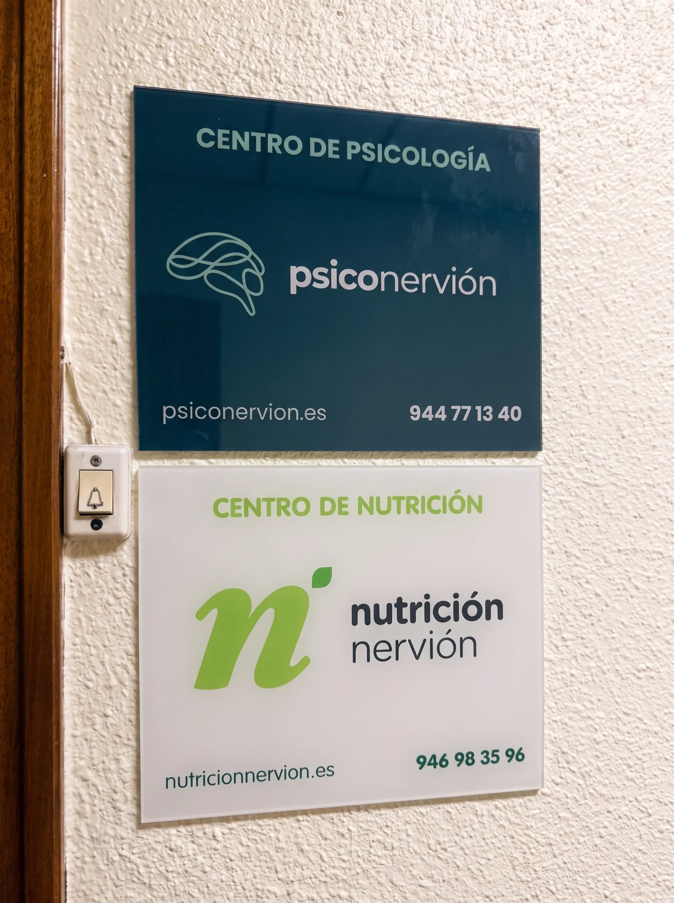 Placas de Psiconervión, centro de psicología, y de Nutrición Nervión, con el timbre al lado.