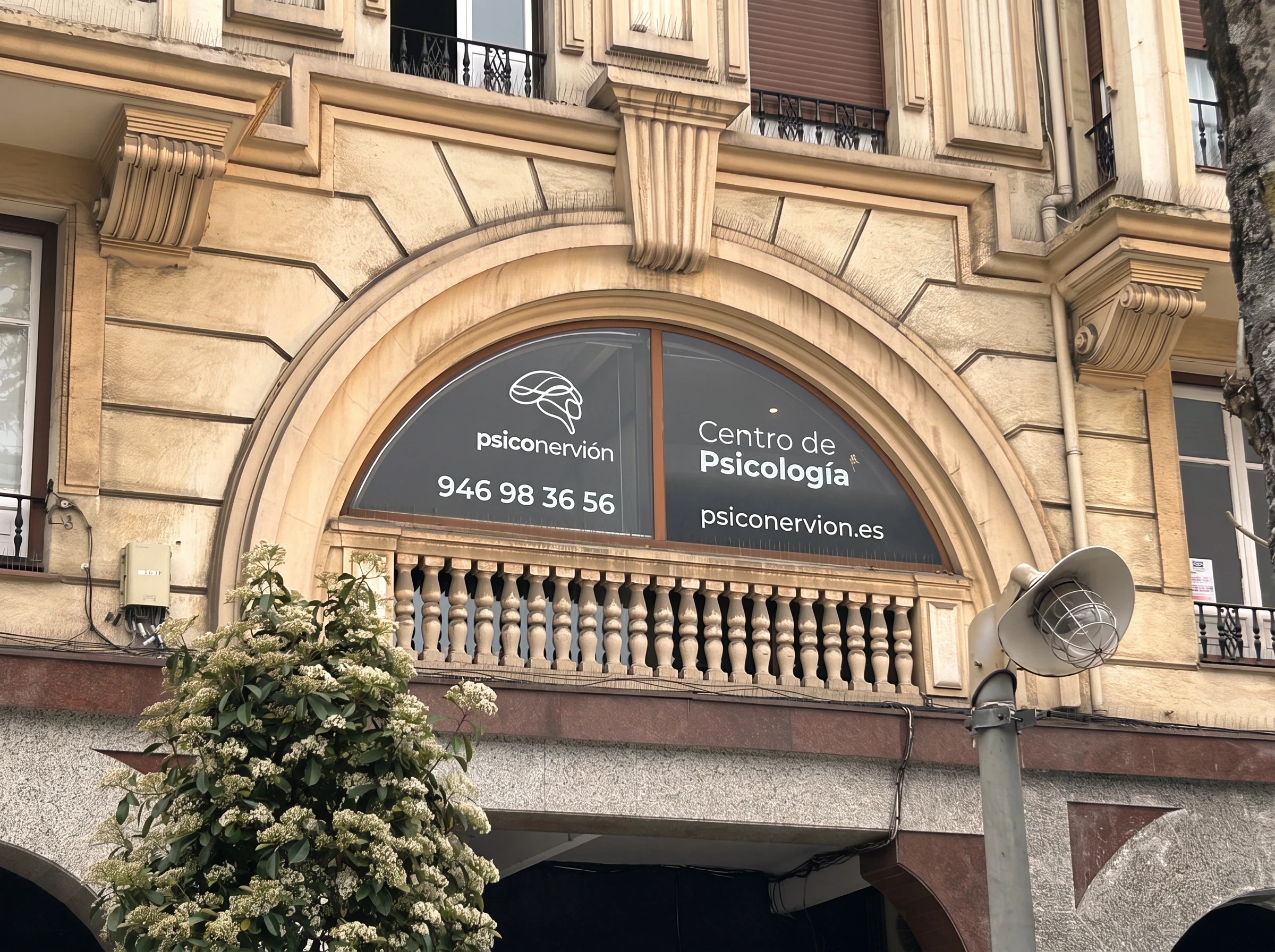 Ventanal en arco del primer piso con el rótulo de Psiconervión, centro de psicología, en la fachada del centro Psiconervión Barakaldo – Herriko Plaza.
