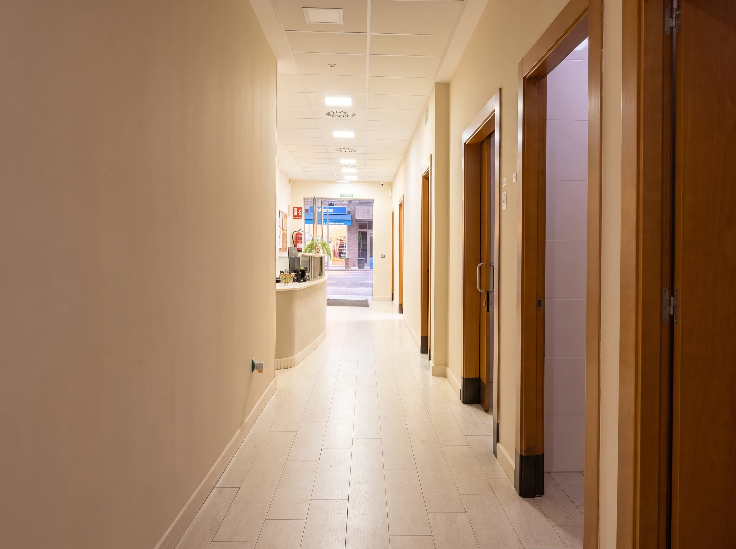 Pasillo del centro Psiconervión Oviedo con las puertas de las consultas y la recepción al fondo.